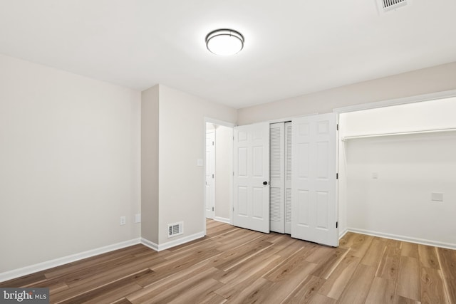 unfurnished bedroom featuring baseboards, visible vents, and light wood-type flooring