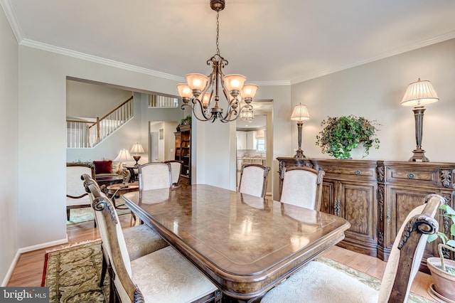 dining area featuring stairs, crown molding, light wood-type flooring, and a chandelier