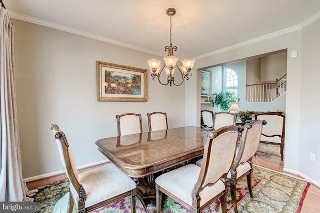 dining room with light wood-type flooring, crown molding, baseboards, a chandelier, and stairs