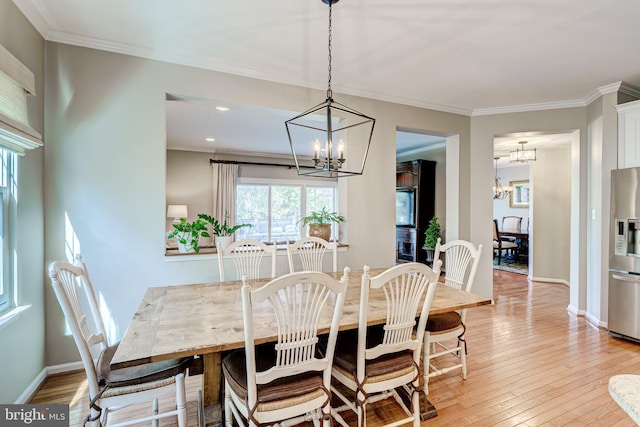 dining area with a notable chandelier, light wood-type flooring, baseboards, and ornamental molding