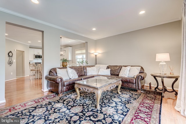 living room with recessed lighting, baseboards, light wood-style flooring, and crown molding