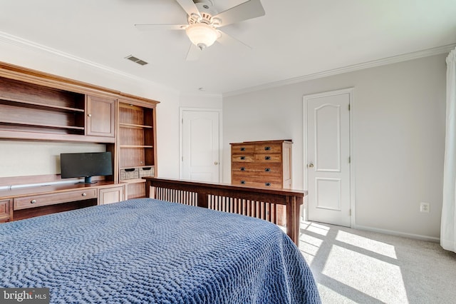 bedroom featuring visible vents, baseboards, light colored carpet, ornamental molding, and built in desk