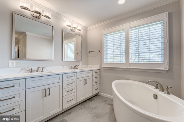 bathroom featuring ornamental molding, a sink, double vanity, baseboards, and a soaking tub