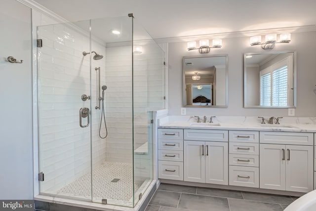 full bathroom featuring a sink, a shower stall, crown molding, and double vanity