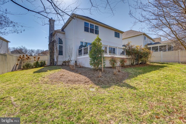 back of property featuring a fenced backyard, a chimney, and a yard