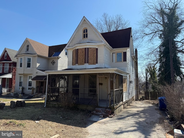 view of front facade featuring covered porch and roof with shingles