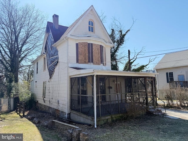 view of front of home with a sunroom and a chimney