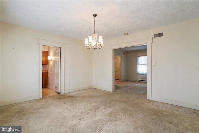 unfurnished dining area featuring visible vents, carpet, a chandelier, baseboard heating, and a textured ceiling