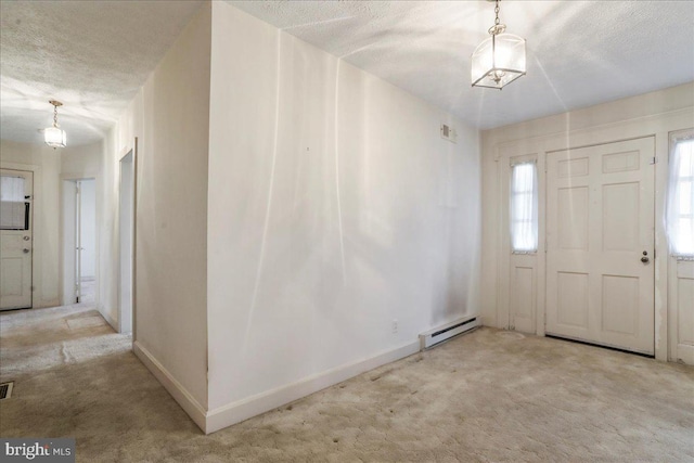 carpeted entryway with visible vents, a textured ceiling, a baseboard heating unit, and baseboards