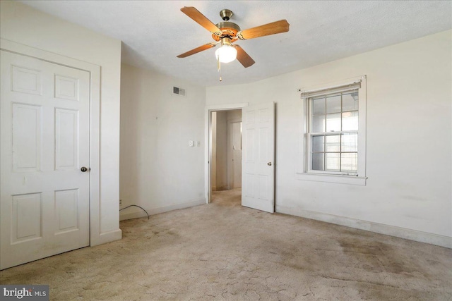 unfurnished bedroom with carpet flooring, baseboards, visible vents, and a ceiling fan