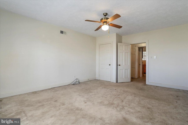 unfurnished bedroom with visible vents, baseboards, a textured ceiling, and carpet flooring