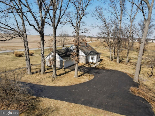 view of front of property featuring aphalt driveway and a rural view