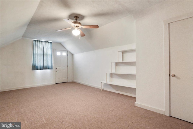 additional living space with carpet flooring, baseboards, ceiling fan, and vaulted ceiling