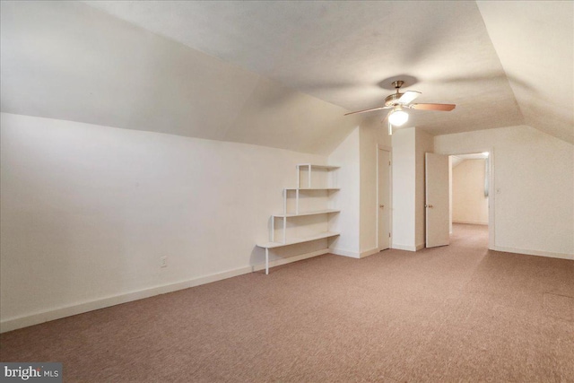 bonus room with vaulted ceiling, baseboards, and light carpet