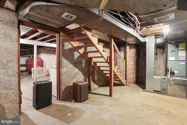 unfinished basement featuring heating unit, visible vents, heating fuel, and stairs