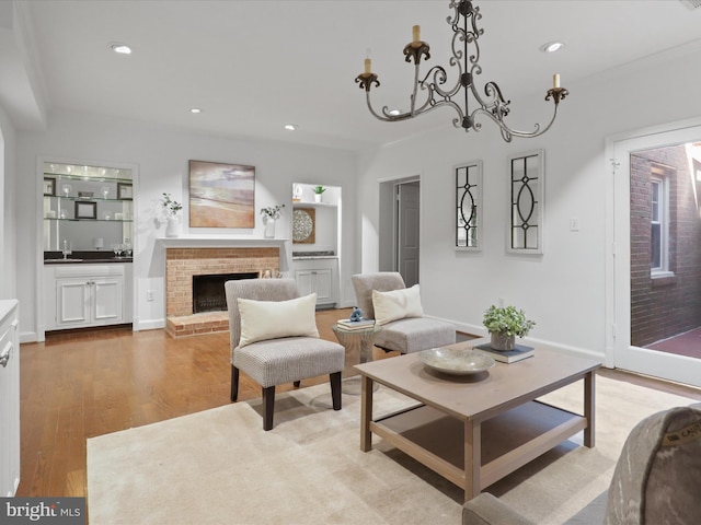 living room featuring light wood finished floors, recessed lighting, a fireplace, and baseboards