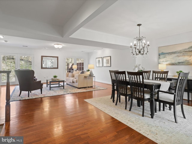 dining area featuring hardwood / wood-style flooring, a healthy amount of sunlight, baseboards, and a chandelier