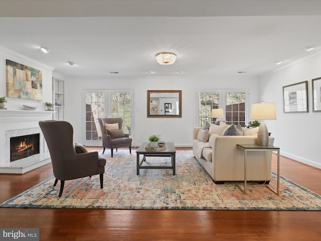 living area featuring a wealth of natural light, french doors, wood finished floors, and ornamental molding