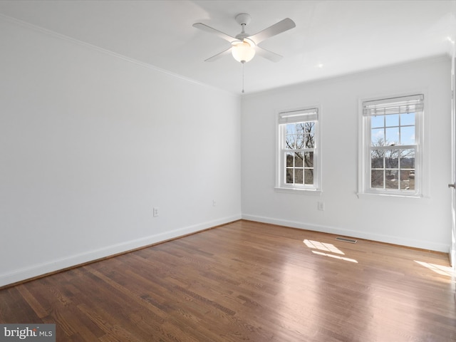 spare room with visible vents, baseboards, wood finished floors, and a ceiling fan