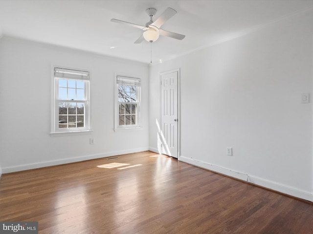 spare room with a ceiling fan, baseboards, and wood finished floors