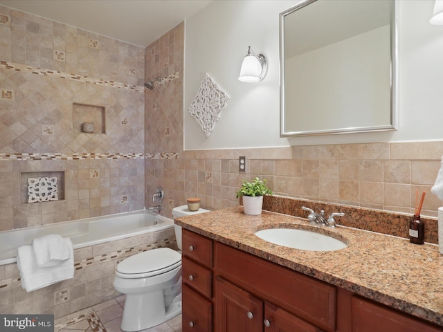 bathroom with tile patterned flooring, toilet, tile walls, and vanity