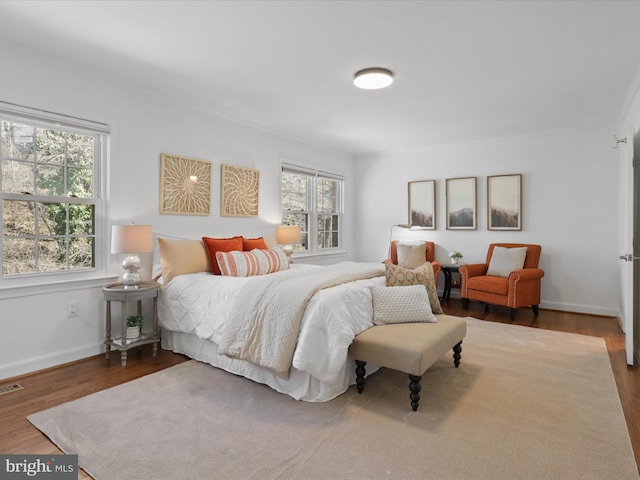 bedroom featuring visible vents, wood finished floors, and baseboards