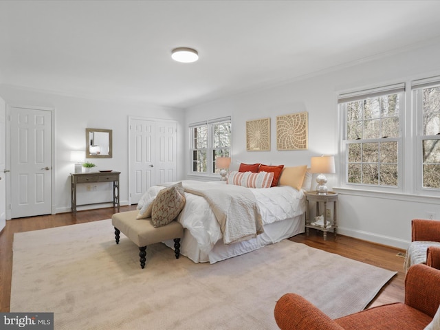 bedroom featuring a closet, baseboards, and wood finished floors