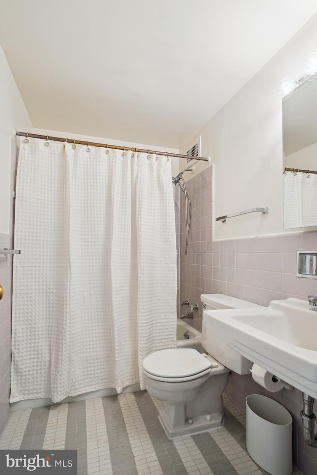 2475 Virginia Ave NW Unit 618, Washington, DC 20037 - bathroom featuring a wainscoted wall, tile patterned flooring, shower / tub combo, tile walls, and toilet