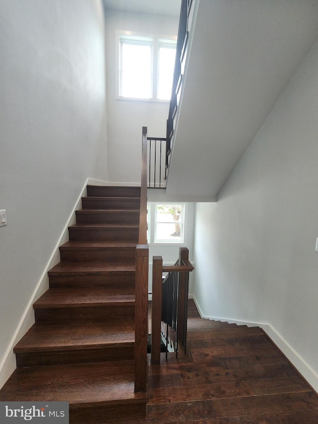 stairway with baseboards and wood finished floors