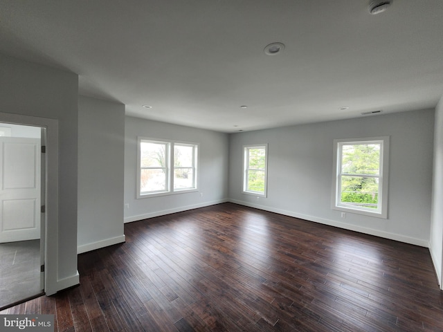 spare room featuring visible vents, baseboards, recessed lighting, and dark wood-style floors
