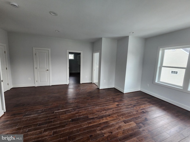 unfurnished room featuring baseboards, dark wood finished floors, and recessed lighting