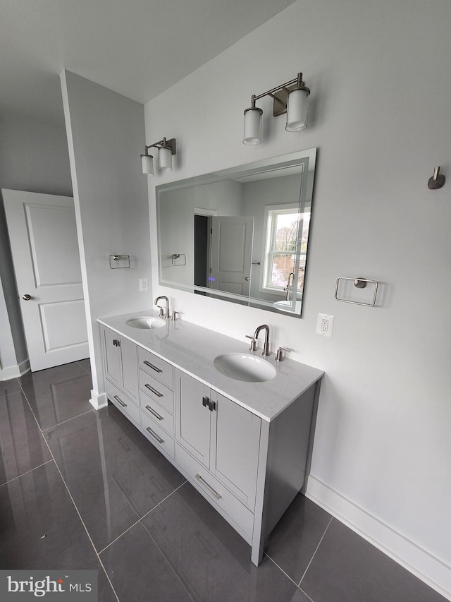 bathroom featuring double vanity, baseboards, and a sink