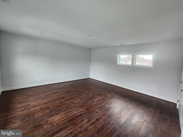 unfurnished room featuring dark wood-style floors and baseboards