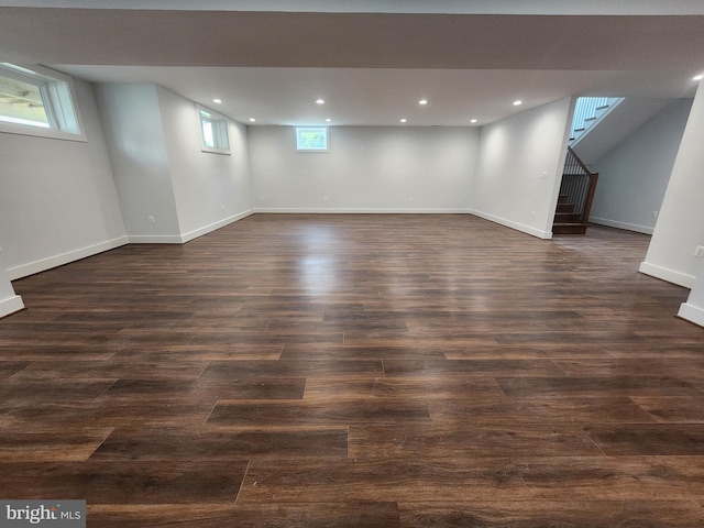 below grade area featuring recessed lighting, stairway, dark wood-style flooring, and baseboards