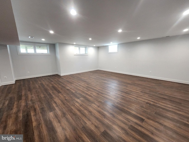 basement with dark wood-type flooring, visible vents, baseboards, and recessed lighting