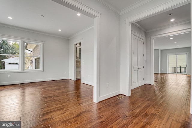 empty room featuring visible vents, baseboards, crown molding, recessed lighting, and wood finished floors