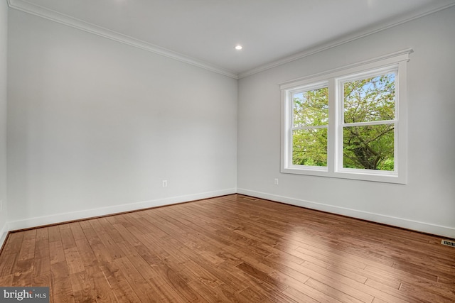 unfurnished room featuring crown molding, wood finished floors, and baseboards