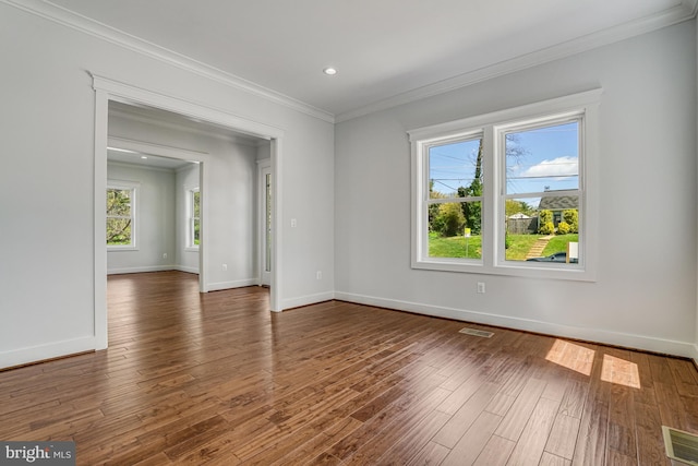 spare room with visible vents, baseboards, ornamental molding, recessed lighting, and wood finished floors