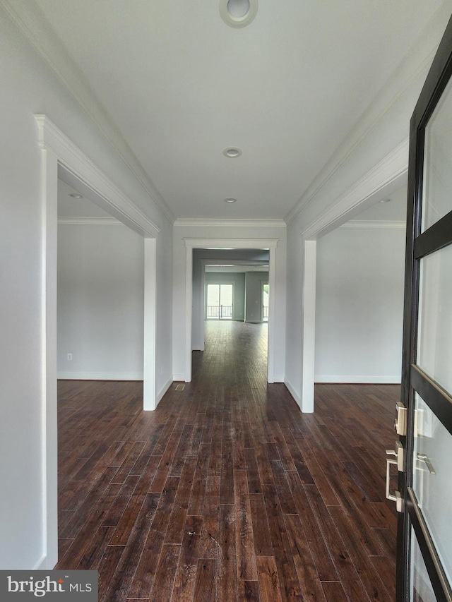 hall featuring crown molding, wood finished floors, and baseboards