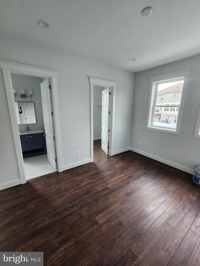 unfurnished bedroom with visible vents, baseboards, a spacious closet, recessed lighting, and wood-type flooring