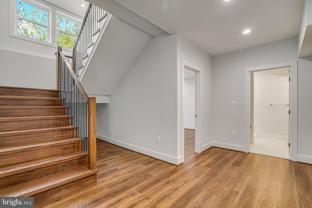 stairs with wood finished floors, baseboards, and recessed lighting
