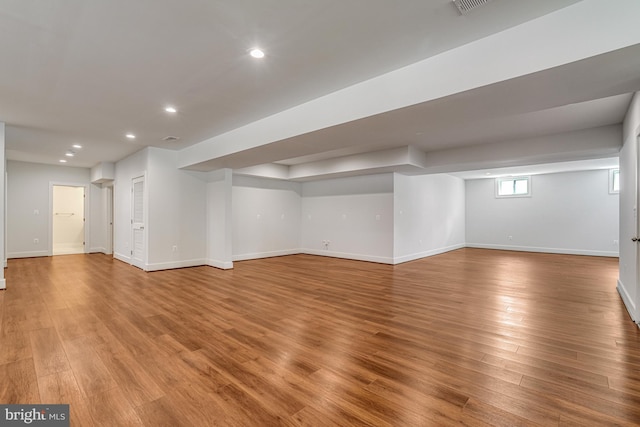 below grade area featuring baseboards, light wood finished floors, and recessed lighting