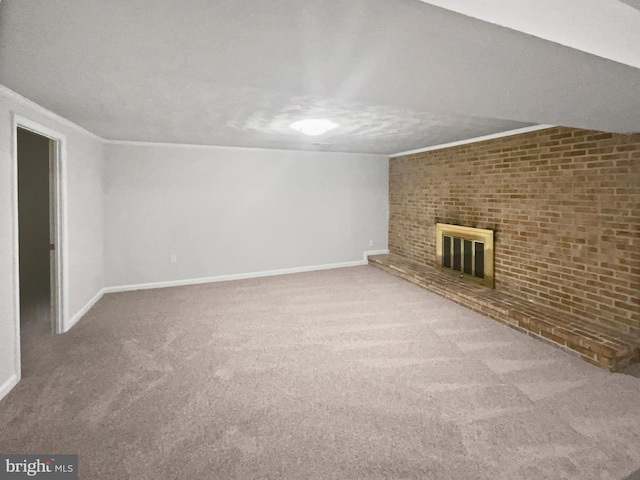 unfurnished living room with ornamental molding, carpet floors, brick wall, baseboards, and a brick fireplace