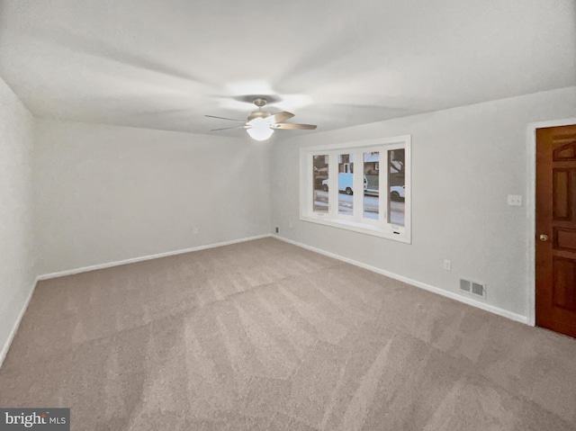 empty room with visible vents, baseboards, carpet, and a ceiling fan