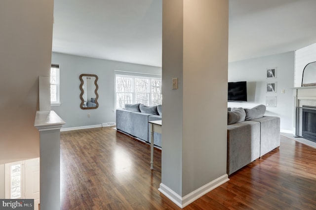 interior space featuring a wealth of natural light, baseboards, and dark wood-style flooring