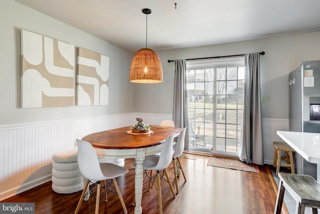 dining area with wainscoting and wood finished floors