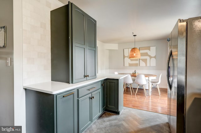 kitchen with parquet flooring, pendant lighting, light countertops, and freestanding refrigerator