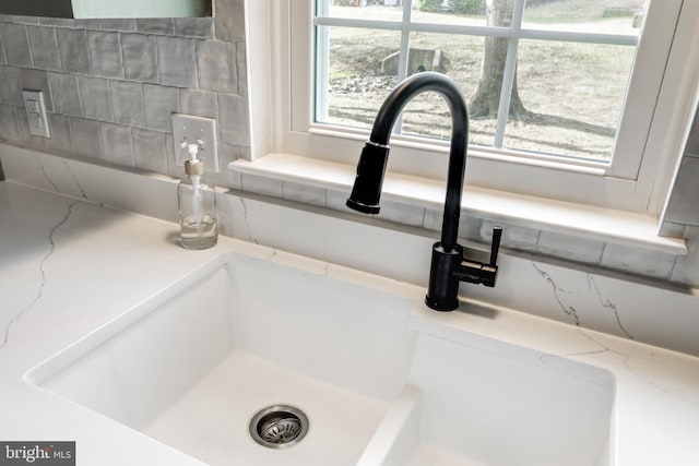 interior details featuring a sink and tasteful backsplash