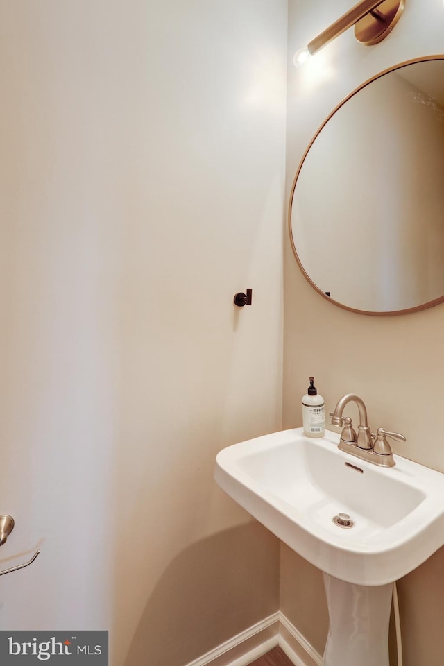 bathroom featuring baseboards and a sink