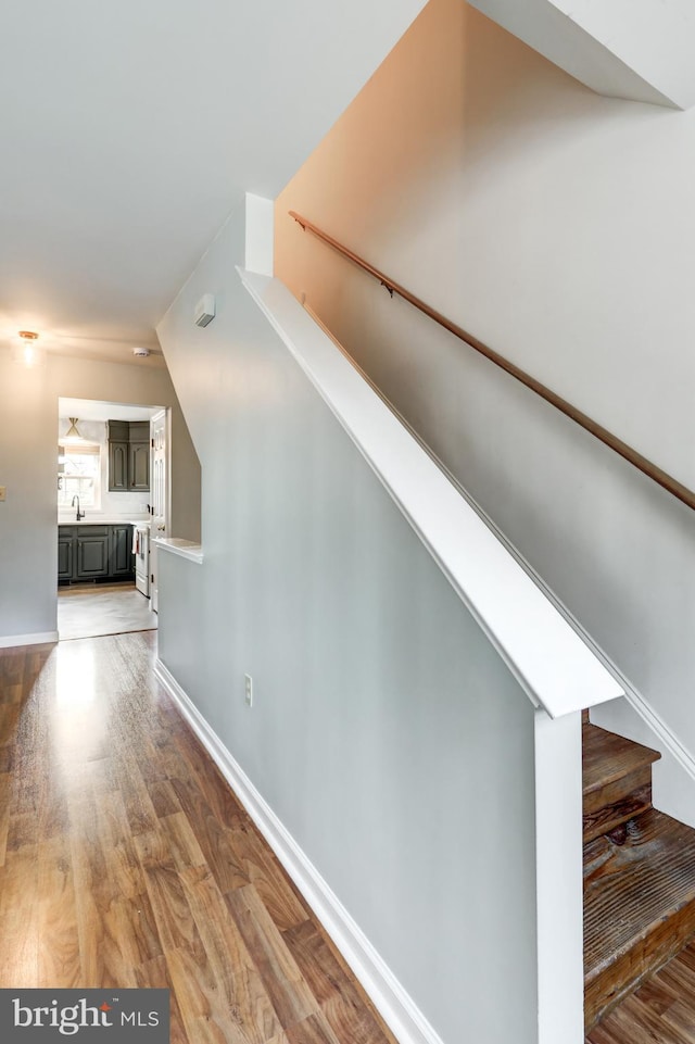 stairway with baseboards and wood finished floors